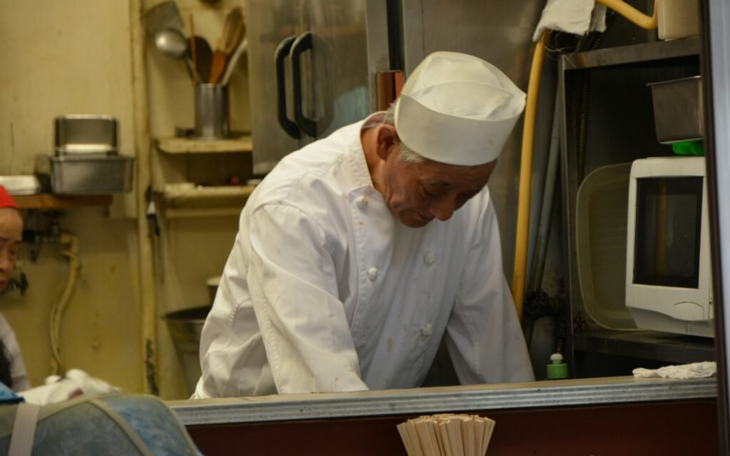 A chef carefully plating a dish in a restaurant kitchen