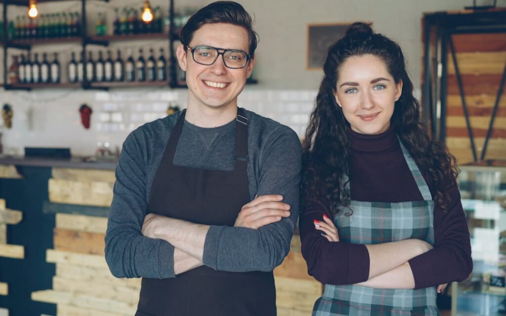 Two shop owners standing together behind a counter
