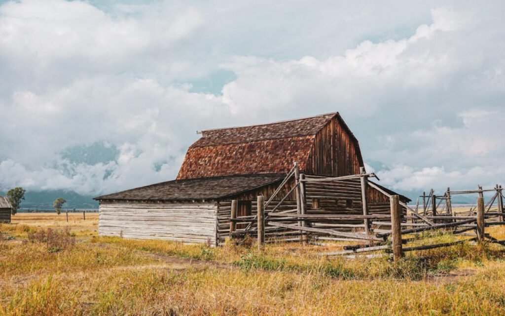 An old red barn standing in a green field