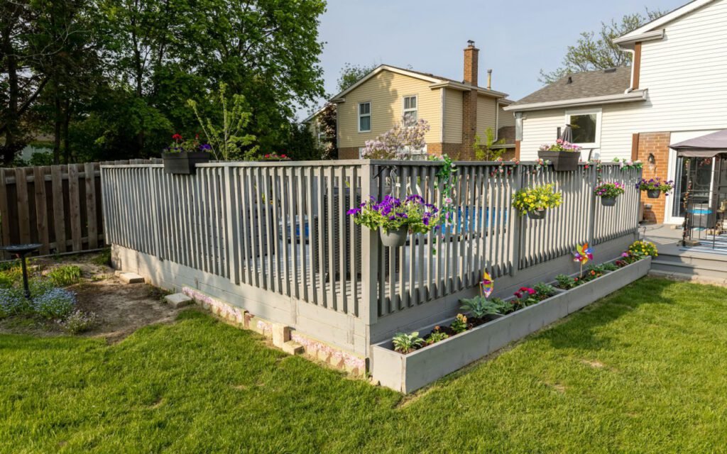 A wooden fence along the edge of a sunny garden