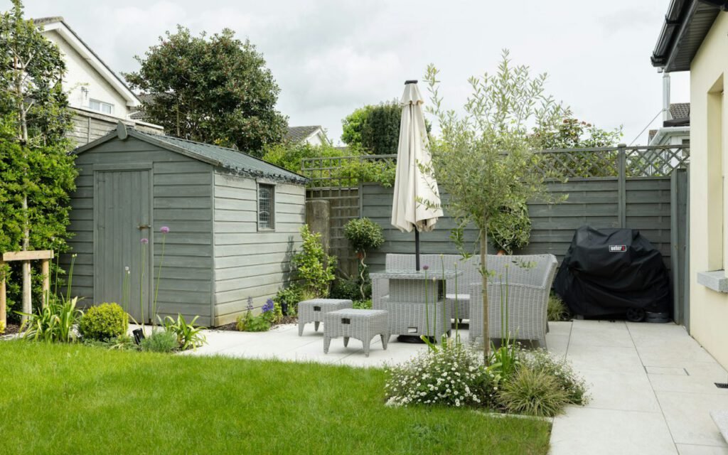 A patio with flowering plants in large containers