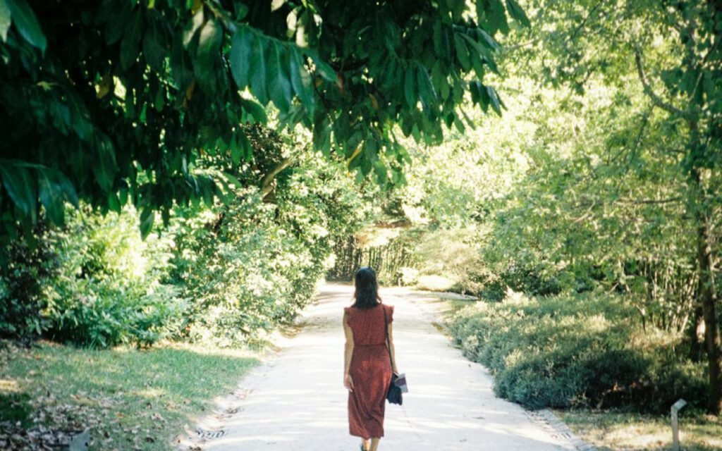 A woman walking alone on a wooded trail
