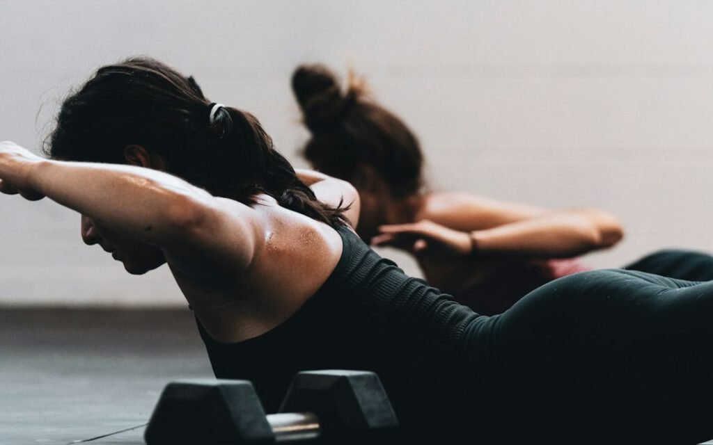 A group of people exercising together on the floor of a fitness studio