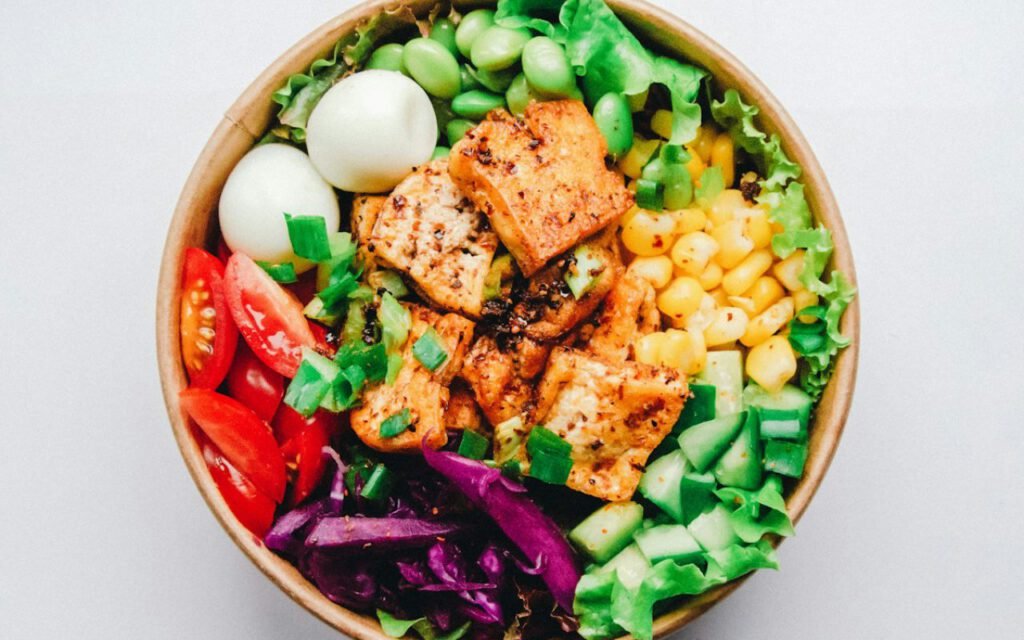 A bowl with salmon, rice and fresh vegetables