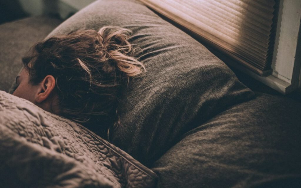 A person sleeping peacefully in a bright bedroom