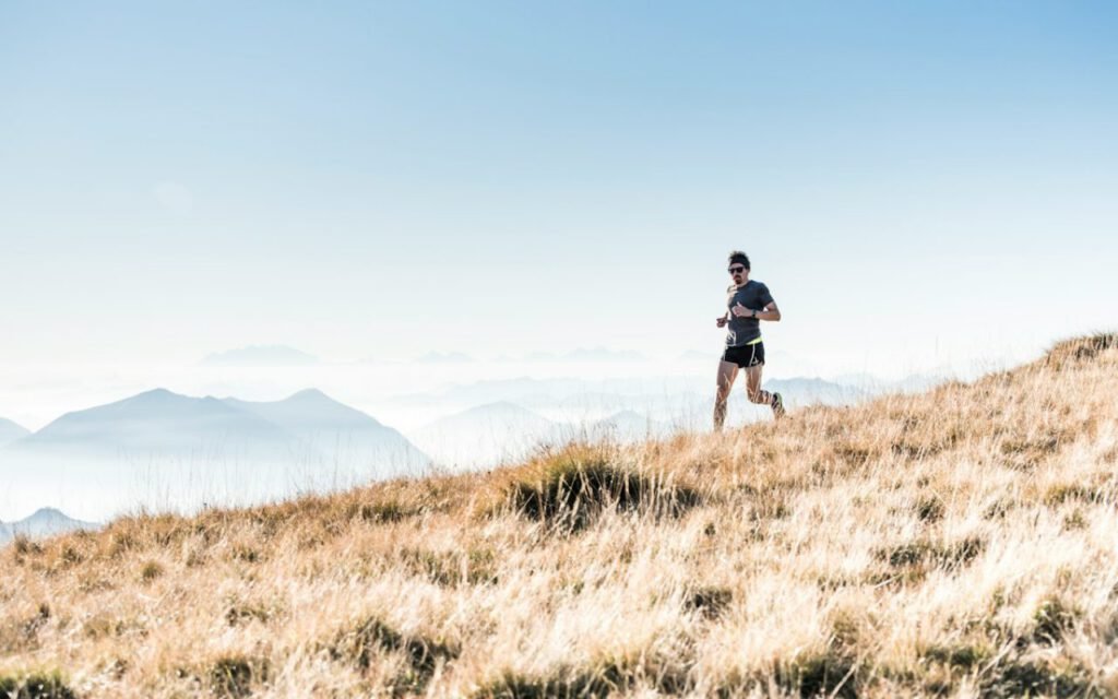 A runner jogging slowly up a gentle trail hill