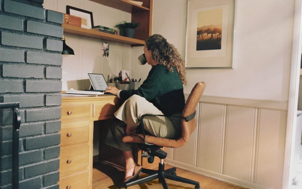 A tidy home office desk with a raised monitor and a separate keyboard