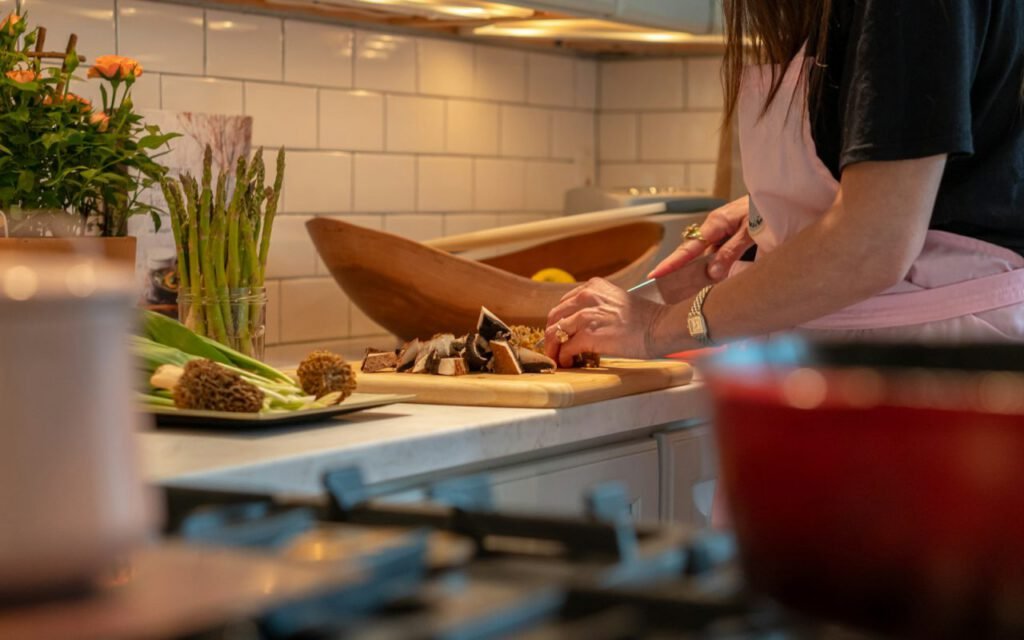 Hands chopping fresh vegetables on a wooden cutting board