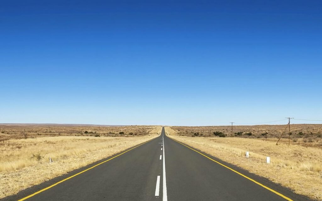 A long straight highway stretching toward the horizon at dusk