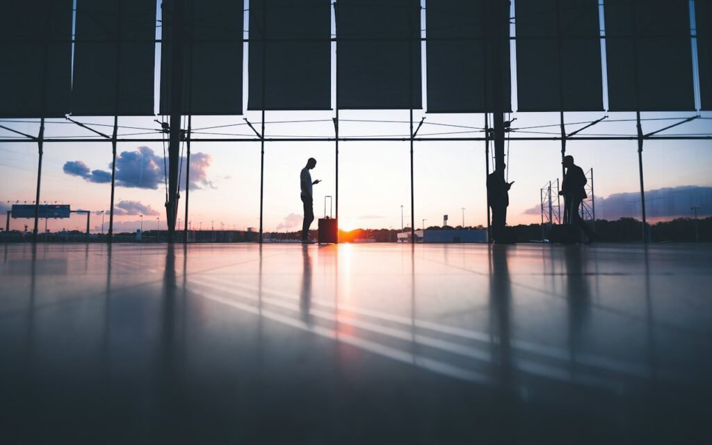 A traveler waiting by a large airport window watching planes